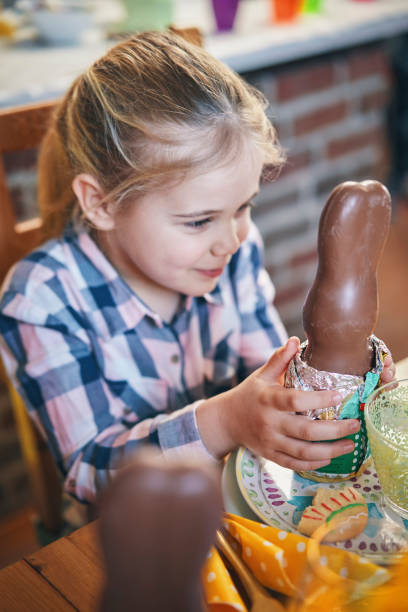 Cute Little Kids Eating Chocolate Easter Bunny and Having Fun on a Decorated Easter Table