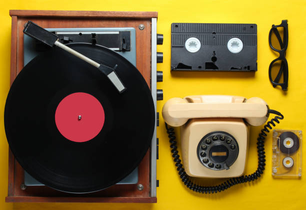 istock Old-fashioned objects on yellow background. Retro style, 80s, pop culture. Top view. Vinyl player, rotary phone, video, audio tape 1138194233
