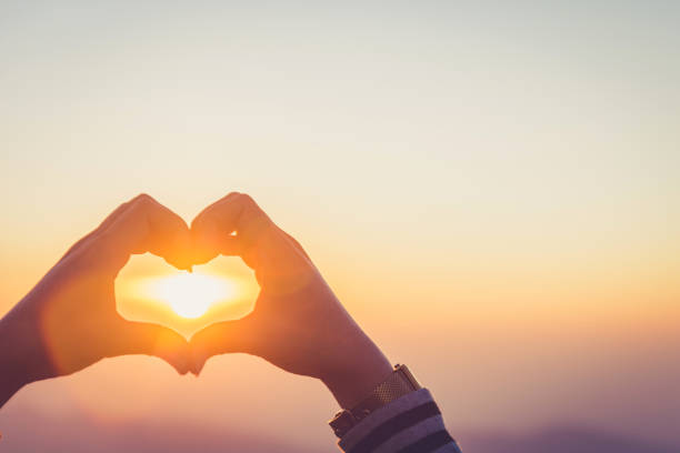istock Hands forming a heart shape with sunrise silhouette,copy space,warm retro tone. 1138195208