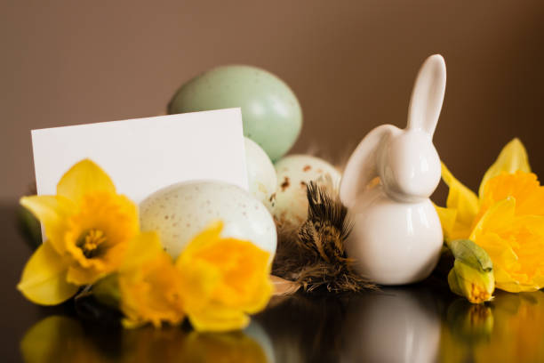 istock Small white rabbit figurine with easter eggs and narcissus 1138197909