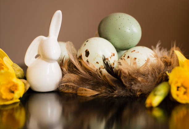 piccola statuetta di coniglio bianco con uova di pasqua e narciso - easter egg figurine easter holiday foto e immagini stock