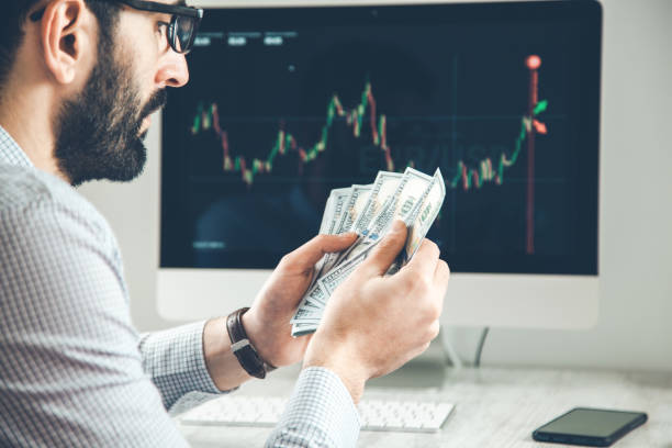 istock man hand money with  trading computer screen background 1138201602