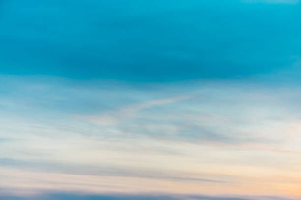 ciel de coucher de soleil avec des nuages de lumière jaunes oranges. dégradé de ciel bleu lisse coloré. fond naturel du lever du soleil. le paradis est incroyable. atmosphère de soirée légèrement nuageux. beau temps à l'aube. - heaven cloudscape majestic sky photos et images de collection