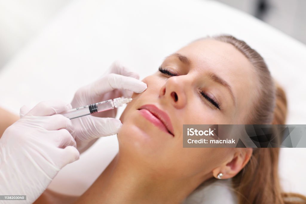 Close up of hands of cosmetologist making botox injection in female lips Hands of cosmetologist making botox injection in female lips Botulinum Toxin Injection Stock Photo