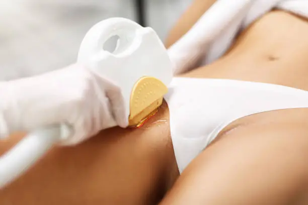 Picture Of Beautician Giving Epilation Laser Treatment To Woman On Bikini