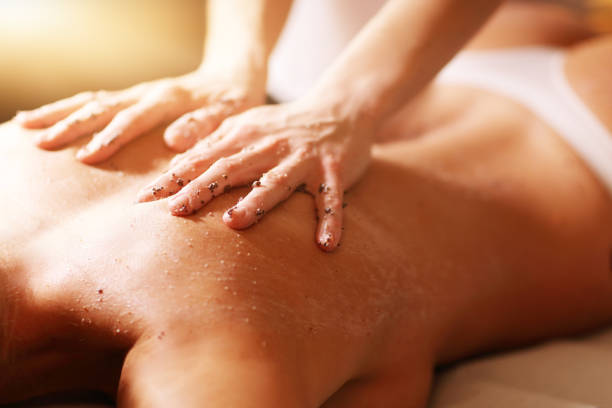 femme heureuse ayant épluchage dans le salon de spa - lastone therapy spa treatment massaging massage therapist photos et images de collection
