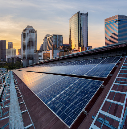 Instalación fotovoltaica del panel solar en un tejado de fábrica, Fondo de cielo azul soleado, fuente de electricidad alternativa-concepto de recursos sostenibles. photo