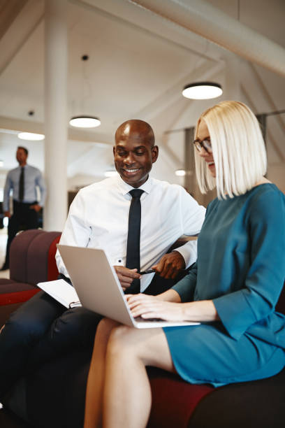 istock Smiling business coworkers discussing work together on an office sofa 1138206897