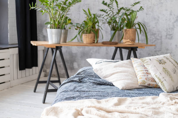 istock Not made bed with pillows in the interior with houseplants 1138210803