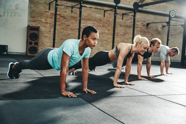 istock Diverse friends doing pushups together on a gym floor 1138211452