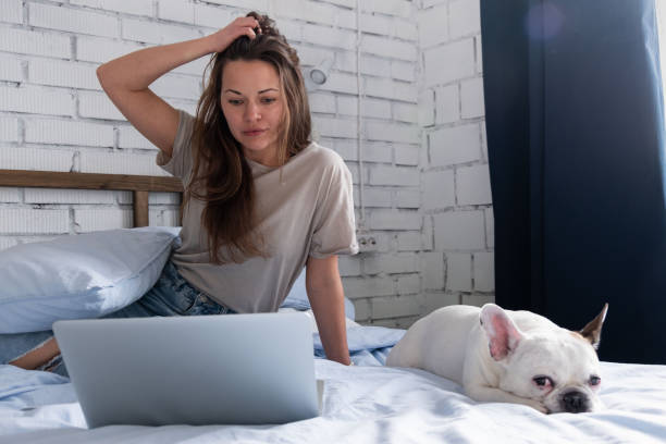 istock Pensive woman working at the computer on the bed 1138212390