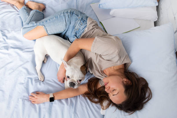 istock Lovely young woman sleeping on the bed with her charming dog 1138213041