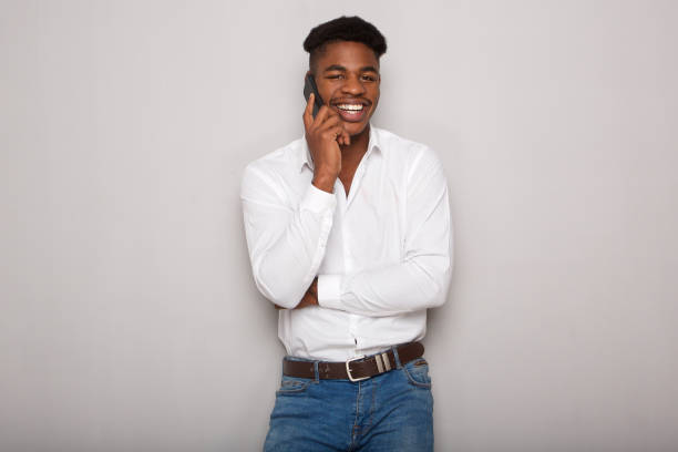 istock happy african american man talking on cellphone by gray wall 1138213103