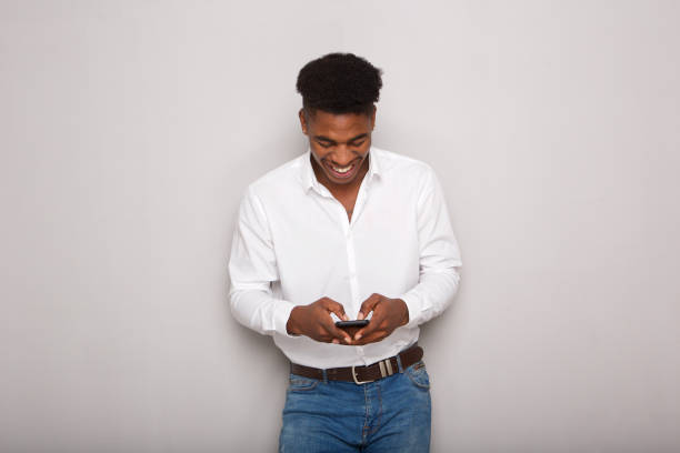 istock young black man smiling and looking at cellphone 1138213112