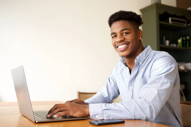 istock charming young african american man working with laptop computer at office 1138213226
