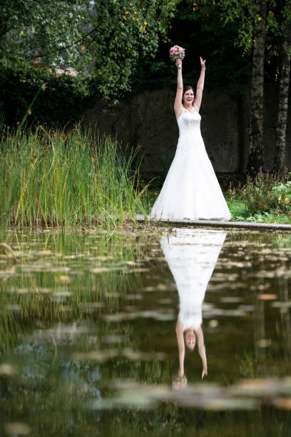 istock Happy bride laughing in the park with her hands up 1138214031