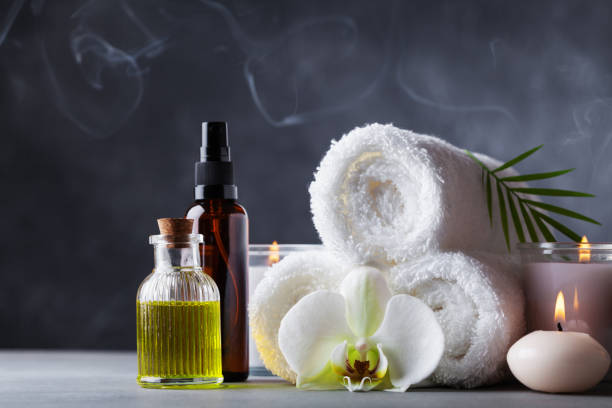 Aromatherapy, spa, beauty treatment and wellness background with massage oil, orchid flowers, towels, cosmetic products and burning candles. Aromatherapy, spa, beauty treatment and wellness background with massage oil, orchid flowers, towels, cosmetic products and burning candles with incense. incense photos stock pictures, royalty-free photos & images