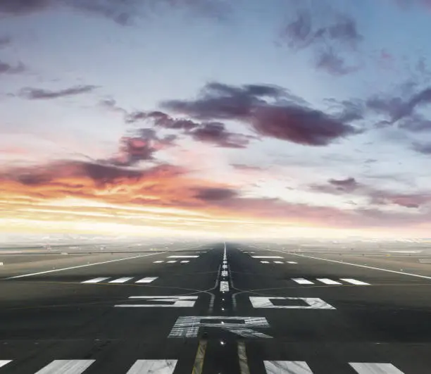Empty airport runway. Concept of modern and fastest mode of transportation. Dramatic sunset sky on background
