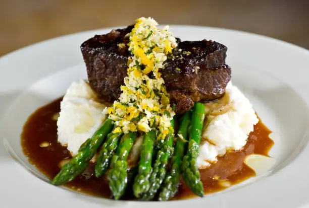 Photo of Filet on a bed of asparagus and mashed potatoes with gravy