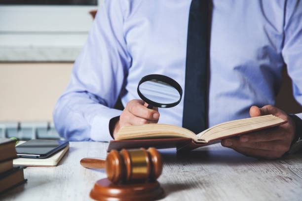 istock man hand magnifier with  book with judge 1138217678