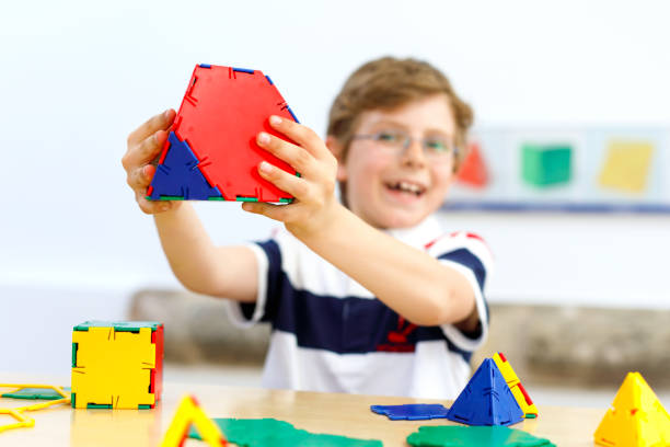 istock Happy kid boy with glasses having fun with building and creating geometric figures, learning mathematics and geometry 1138220569