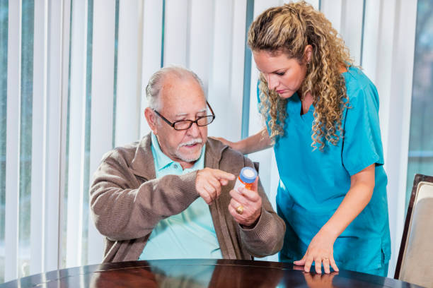istock Home caregiver helping senior man with medication 1138221740