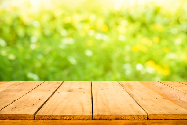 istock Real wood table top texture on blur flower garden background 1138221870