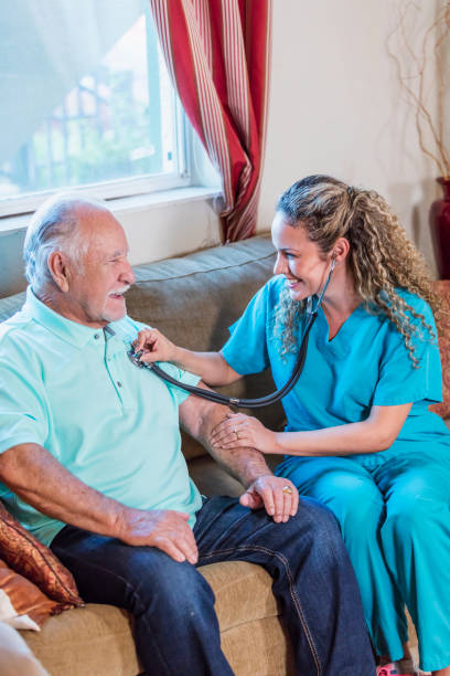 istock Home caregiver with stethoscope examining senior man 1138222151