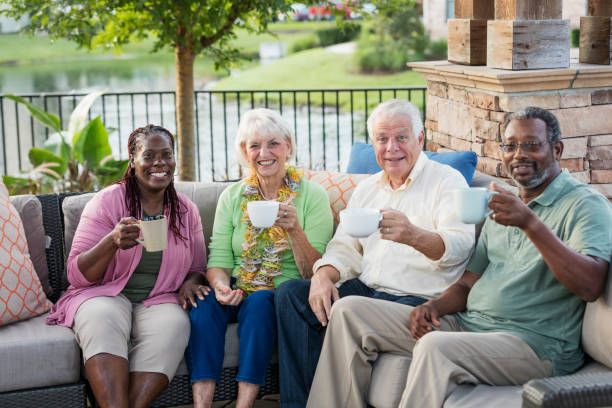 Two older couples hanging out on patio, drinking coffee