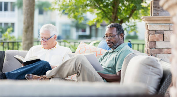 istock Retired men sitting on patio reading books 1138224175