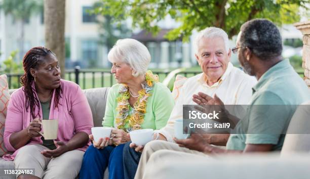 Two Older Couples Hanging Out On Patio Conversing Stock Photo - Download Image Now - Senior Adult, Serious, Discussion