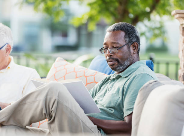 istock Mature African-American man relaxing outdoors, reading 1138225122