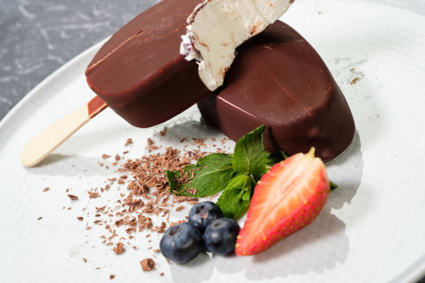istock chocolate butter ice cream popsicles on the white plate with fresh summer berries, strawberries, blueberries 1138226783