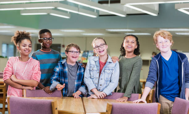 istock Boy with down syndrome, classmates in school library 1138227081