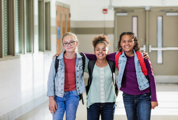 istock Three multi-ethnic girls in elementary school hallway 1138228326