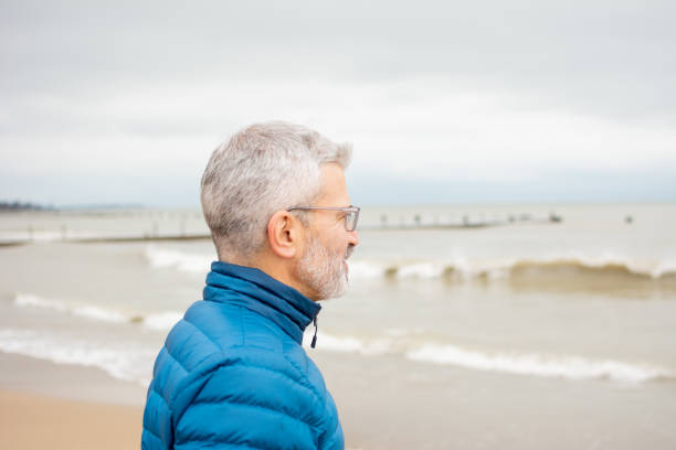 istock Senior Man Close-up on Beach in Winter 1138228636