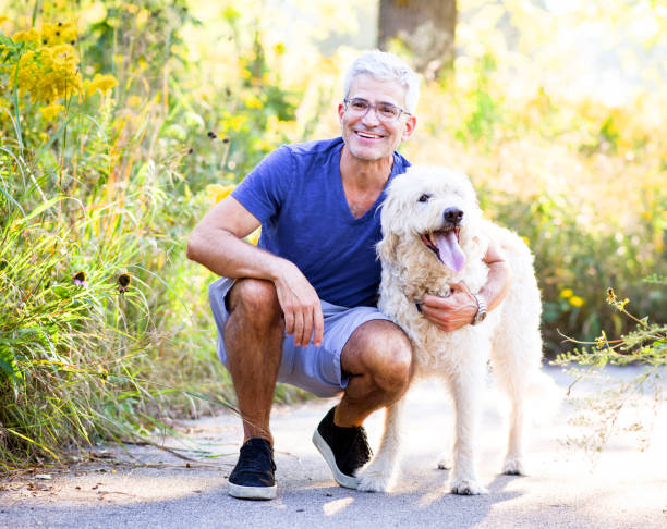 istock Smiling Senior Man Hugging Dog 1138228764