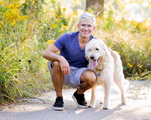 istock Smiling Senior Man Hugging Dog 1138228816