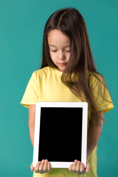 istock little girl holding a blank tablet computer 1138230181
