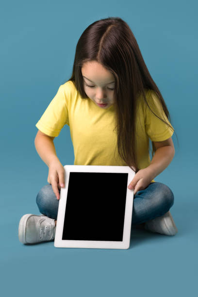 istock little girl holding a blank tablet computer 1138230238