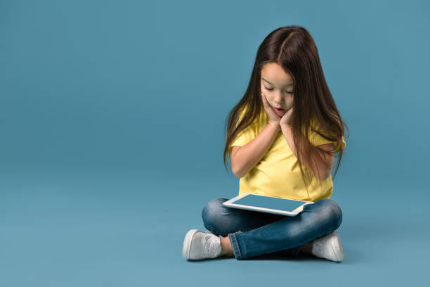 istock little girl holding a blank tablet computer 1138230256