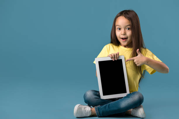 istock little girl holding a blank tablet computer 1138230301