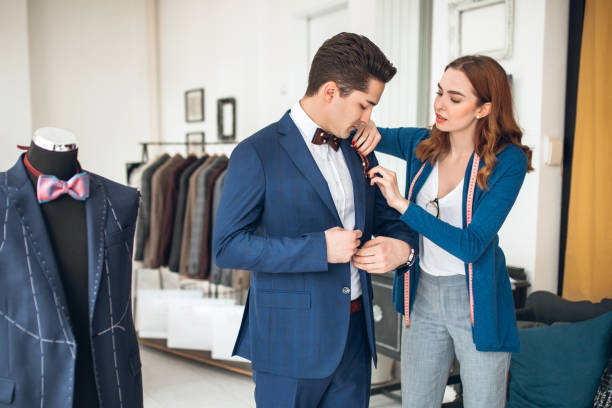 istock Female Tailor Helping Customer Choosing Suit and Bowtie 1138231335