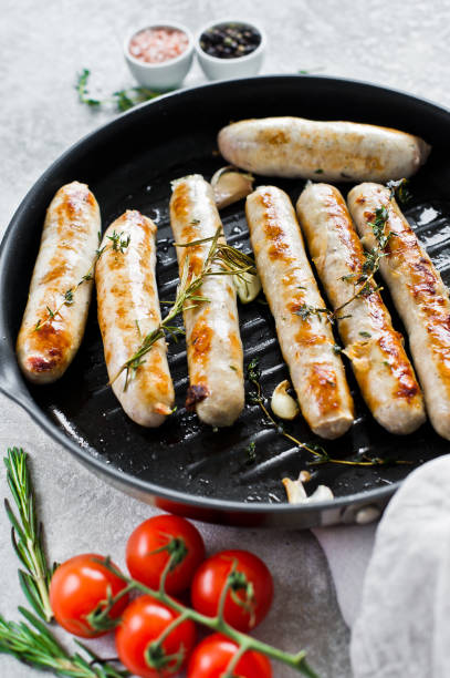 istock Fried sausages in a frying pan. Gray background, side view 1138231819