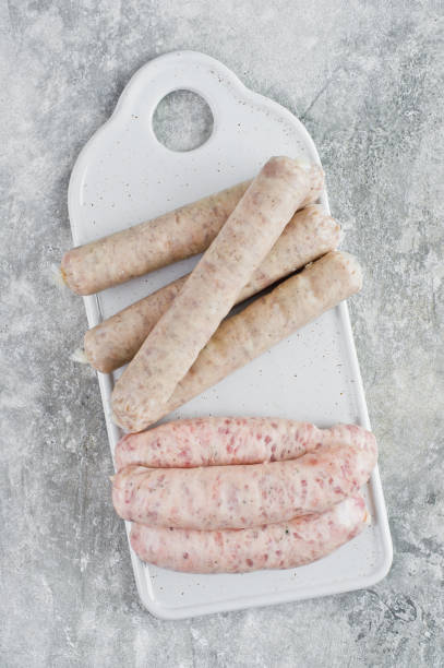 istock Assorted sausages on a ceramic cutting Board, pork, Turkey, chicken. Gray background, top view 1138232601