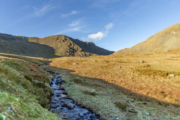 istock Mountain stream with a majestic blue sky and some white clouds 1138234304
