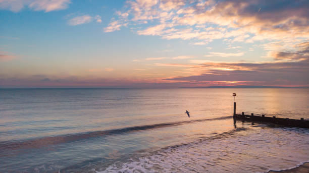 An aerial view of a sunset with reflection on the sea and white clouds An aerial view of a sunset with reflection on the sea and white clouds boscombe photos stock pictures, royalty-free photos & images