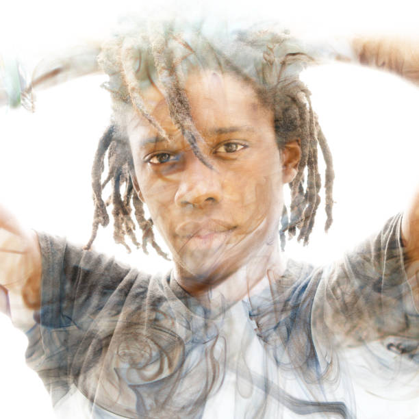 istock Double exposure of a dark skinned man with dreadlocks and hands behind head combined with a photograph of smoke flowing in the air 1138237842
