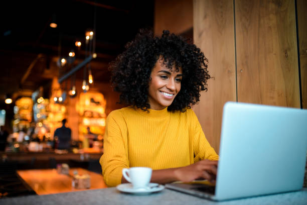 istock Smiling woman using laptop at the bar. 1138239045