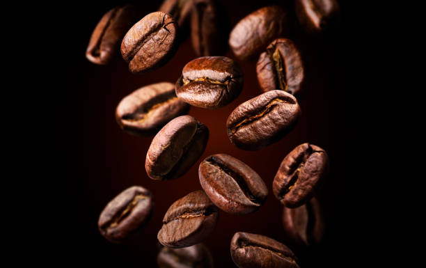 istock Roasted falling or flying coffee beans on black background, close up, brown texture 1138239347